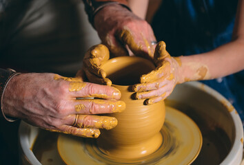 Pottery workshop. Grandpa teaches granddaughter pottery. Clay modeling
