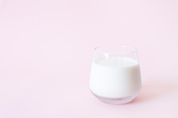 Fresh milk in the glass of pink background