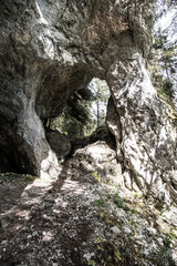 natural arch bellow Poludnica hill in Nizke Tatry mountains in Slovakia with trees on the background