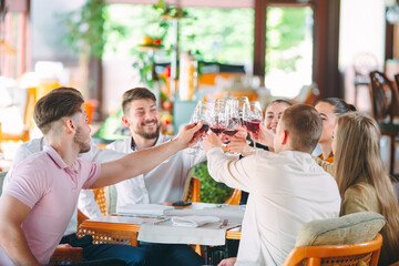 Friends drink wine on the terrace of the restaurant.
