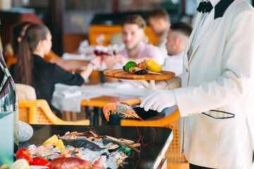 The waiter shifts the seafood on a tray in the restaurant.