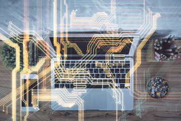 Technology hologram drawing over computer on the desktop background. Top view. Double exposure....
