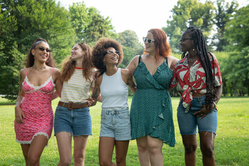 Cinematic shot of young girl friends of different ethnicities are having fun together in green city park on sunny day. Concept of friendship, lifestyle, youth,diversity,multiethnic,
happiness, freedom