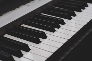 Naklejka premium Black and white piano keys close up diagonal view, classical musical instrument
