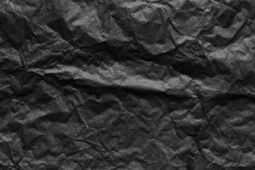 Black paper wrinkled texture background.