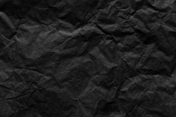 Black paper wrinkled texture background.