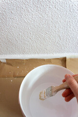 Taking white paint with a brush to paint