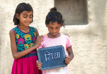 Two Indian rural  girls holding slate