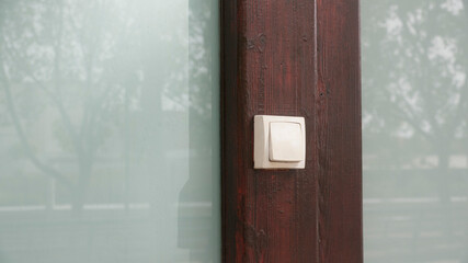 Interruptor blanco en puerta de madera y cristal
