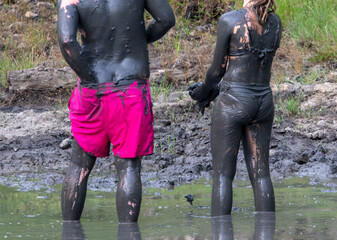 A man and a girl in the healing mud.
