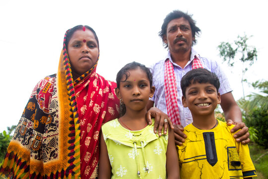Indian Rural Parents and their two children standing in village