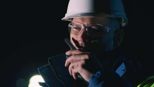 Engineer talking on radio at night