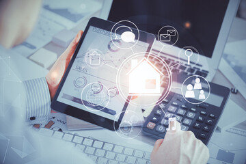 Double exposure of man's hands holding and using a digital device and city drawing.