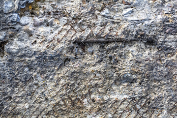 Textured surface of gray concrete wall with scratches and cracks