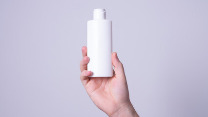 a man holding a bottle of lotion in his hand