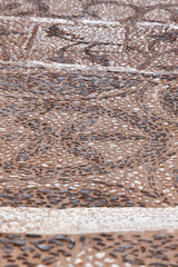Decorated pebble stone street. Textured pavement sidewalk. Ground