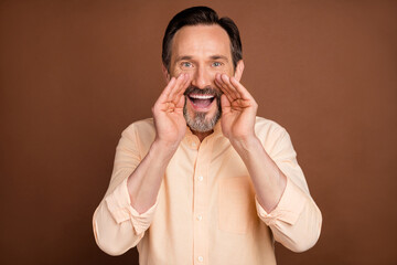 Photo of mature brunet man hands yell wear peach shirt isolated on brown color background
