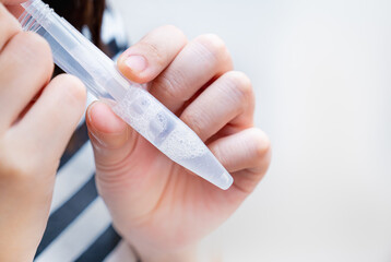 PCR検査キットを使用し、自宅で唾液を採取する女性の写真。PCR検査のイメージ。 - obrazy, fototapety, plakaty