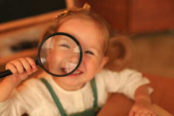 Little girl with accessories and a magnifying glass
