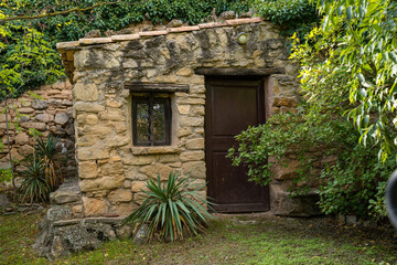 Fototapeta na wymiar casa de piedra medieval rodeada de jardin pintoresco en mitad del bosque en Montsonis lleida cataluña españa