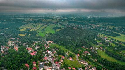 Aerial drone view, small typical polish villagesurrounded by beautiful mountains at summer.