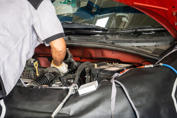 Auto mechanic working and repair car engine in garage