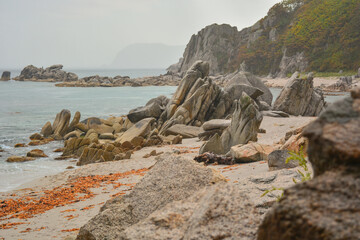 Nice view of the sea and the beach with rocks and kekura on the sand. - 458232953