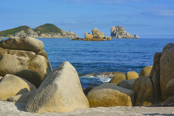 View from the sandy coast to the sea with rocks and large stones. - 458233142