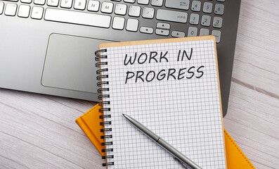Work in Progress text written on a notebook on laptop