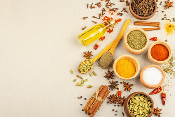 Fototapeta na wymiar A set of spices for cooking curry. Aromatic condiments on light stone concrete background