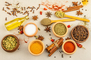 A set of spices for cooking curry. Aromatic condiments on light stone concrete background