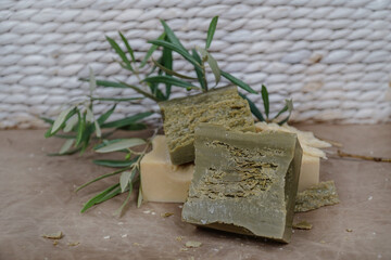 Traditional marsylian soaps made from olive oil. Soap bars on beige and white background with olive branch.   