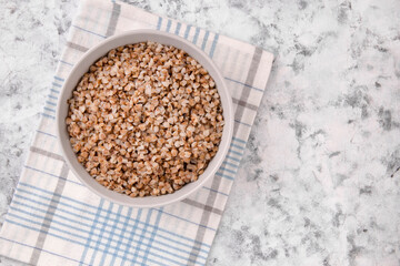 Freshly cooked buckwheat porridge in a plate on a gray background.