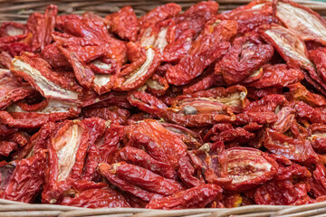 Sun-dried tomatoes in a basket in a street food market, close up. Ripe tomatoes lose most of their water content after spending a majority of their drying time in the sun, close up