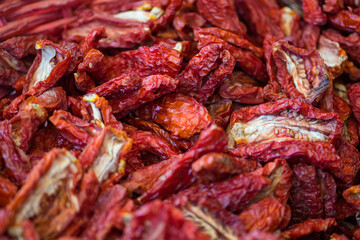 Sun-dried tomatoes in a basket in a street food market, close up. Ripe tomatoes lose most of their water content after spending a majority of their drying time in the sun, close up