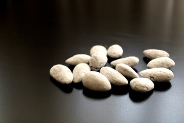 almond candies on black background, sugared almond nuts, heap of sweets