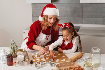 Mother and daughter making Christmas cookies in the kitchen 