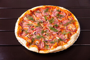 A whole rustic pizza with fried mushrooms, bacon, onion and tomatoes