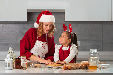 Mother and daughter making Christmas cookies in the kitchen 