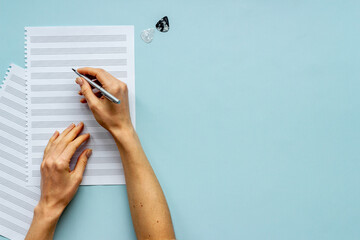 Music sheets with hands writing notes. Compose music concept