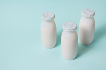 Bottles with probiotics and prebiotics dairy drink on light blue background. Bio yogurt with useful microorganisms. Production with biologically active additives. Fermentation and diet healthy food.
