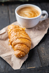 croissant and a cup of coffee fresh portion ready to eat meal snack on the table copy space food background rustic. top view