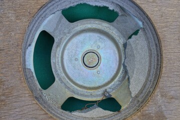 one big round old gray metal speaker on a brown wooden board 