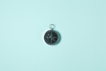 Compass on light blue background. Concept signs symbols. Tool for travel, tourism, science, get lost, business and design and decoration. Flat lay design.