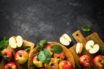 Fresh ripe apples, whole and sliced at black stone table. Top view with copy space.