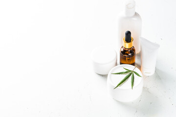 Cannabis cosmetic products at white background. Natural cosmetic concept. Cream, soap, serum, essential oil and others.