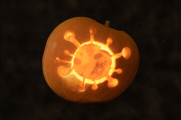 Halloween pumpkin with coronavirus carved inside