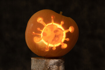 Halloween pumpkin with coronavirus carved inside