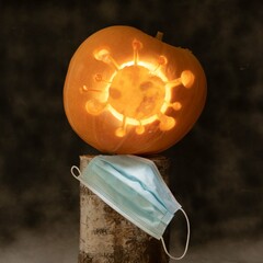 Halloween pumpkin with coronavirus carved inside