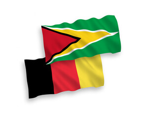 National vector fabric wave flags of Co-operative Republic of Guyana and Belgium isolated on white background. 1 to 2 proportion.